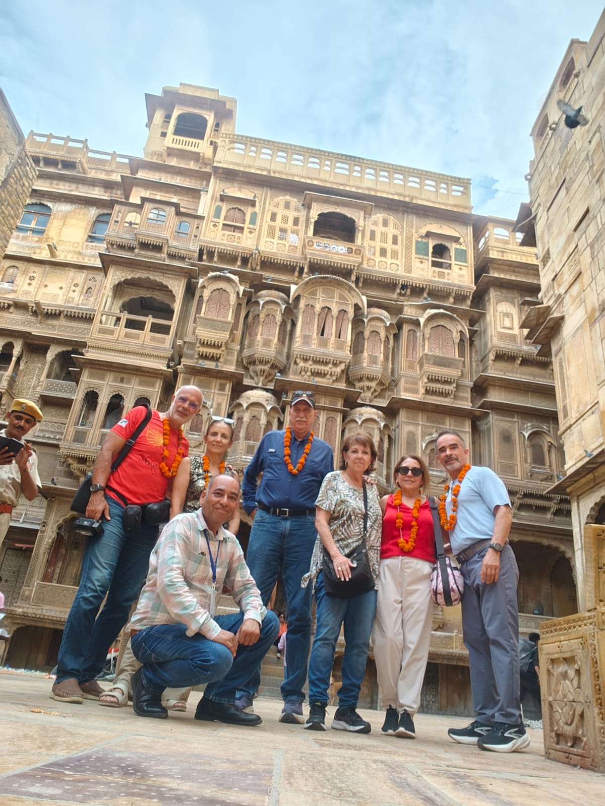 Travellers standing in front of intricately carved sandstone architecture in Jaisalmer.