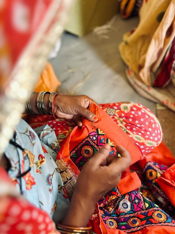 Artisan hands embroidering a richly detailed traditional textile