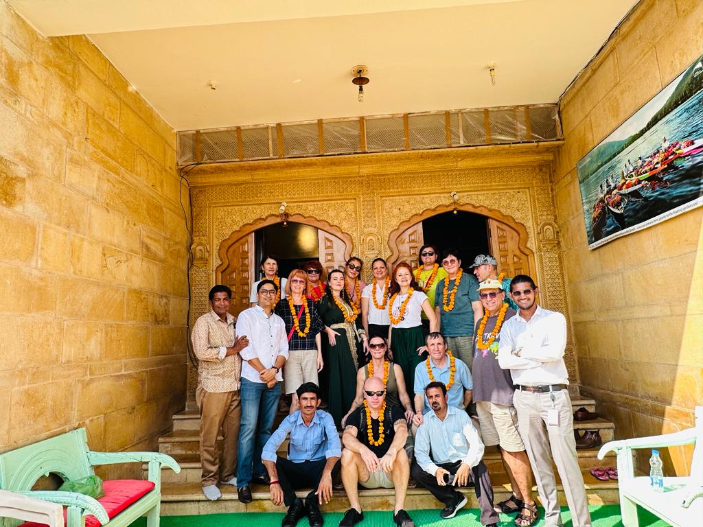 Travellers gathered on the steps of a sandstone building in Jaisalmer.